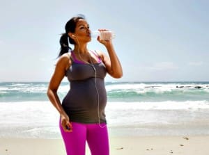 woman getting exercise in her second trimester on beach