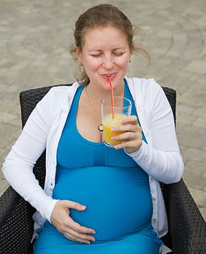 pregnant woman enjoying a beverage dining out