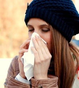 woman having a cold and blowing her nose