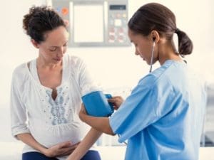 pregnant woman getting her blood pressure checked