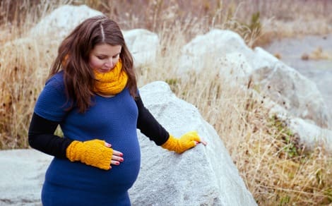 Pregnant woman coping with constipation during pregnancy outside bundled up