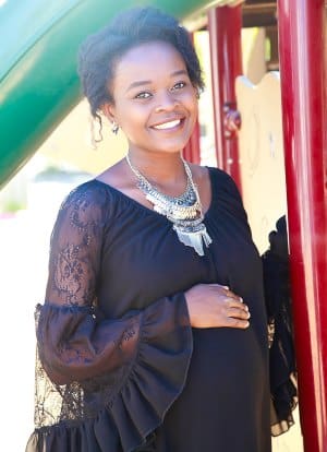 Smiling pregnant woman showing off her best maternity clothes