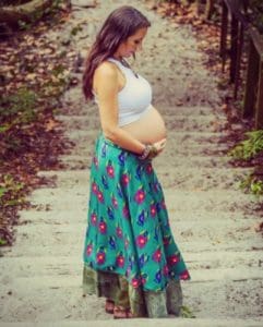 Pregnant woman pauses on steps during her holistic pregnancy