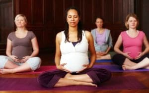 A group of pregnant women meditating during a yoga class