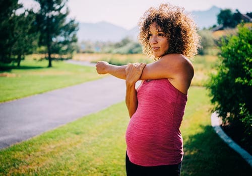Pregnant woman stretches before her morning jog