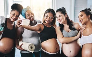Friends pose for a photo after their prenatal yoga class