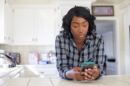Pregnant woman in her kitchen looking at online pregnancy tools