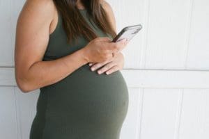 Pregnant woman looking at pregnancy help options online