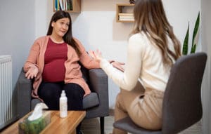 A pregnant woman talking with her therapist during a prenatal counseling session
