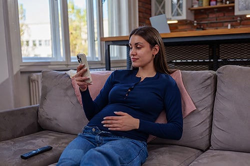 Young woman in her first trimester trying to distinguish between gas bubbles and baby kicks