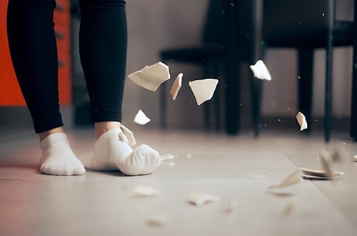 Detail of a plate falling on the floor breaking into pieces 